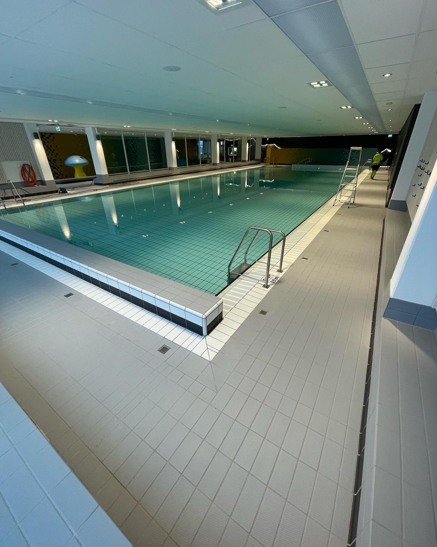 Stor inomhuspool med klinker runt bassäng